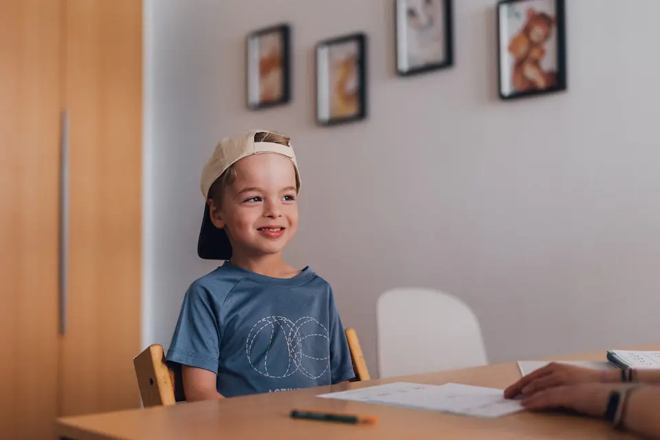 Ein fröhliches Kind bei der Ergotherapie in der Praxis Custers