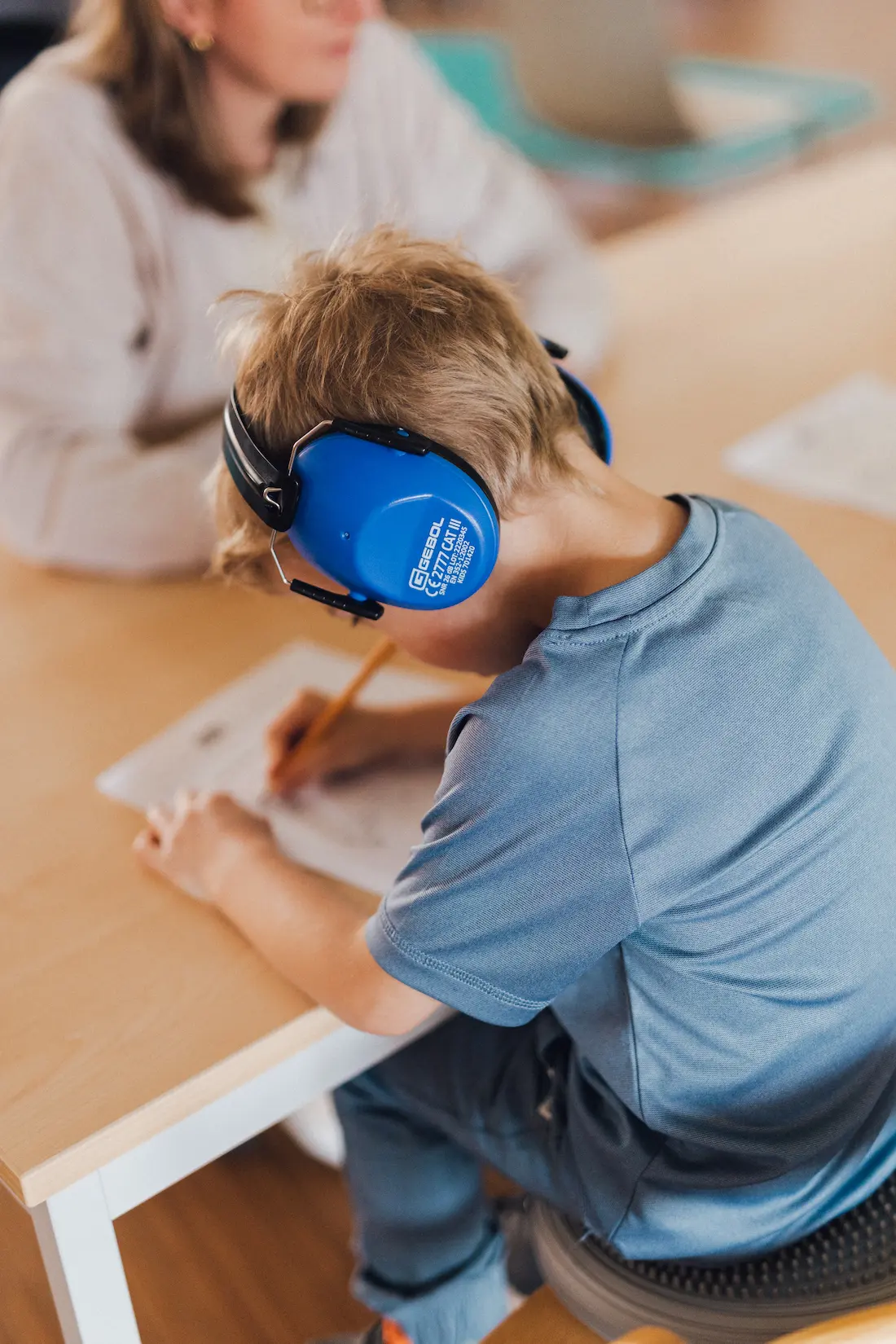 Ein Kind mit Kopfhörern bei der Ergotherapie in der Praxis Custers