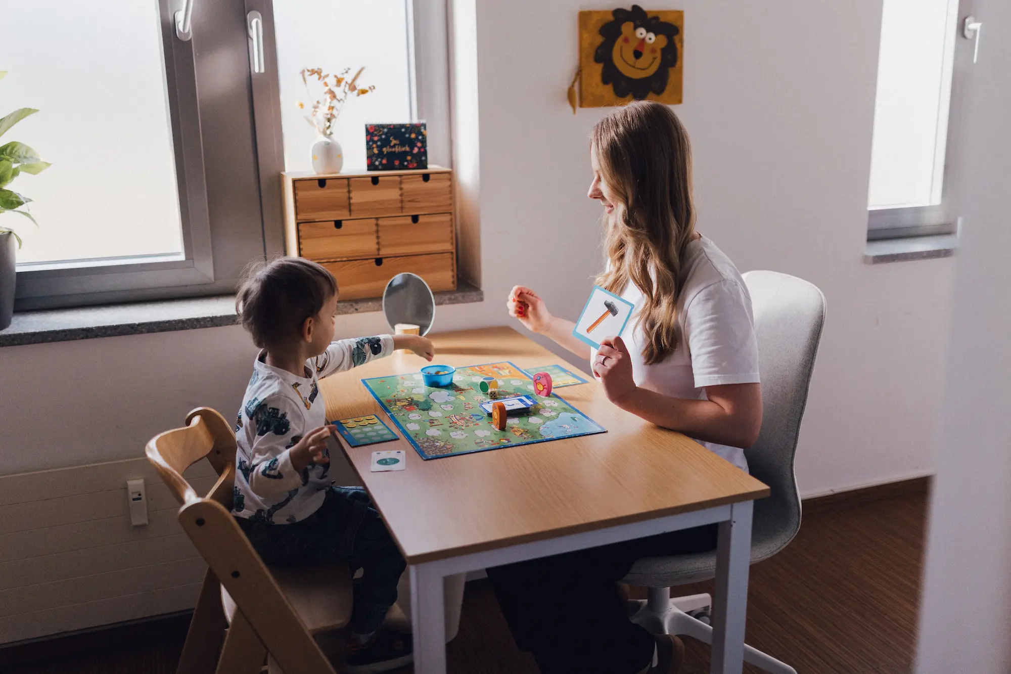 Kind spielt mit Therapeutin in der Praxis Custers