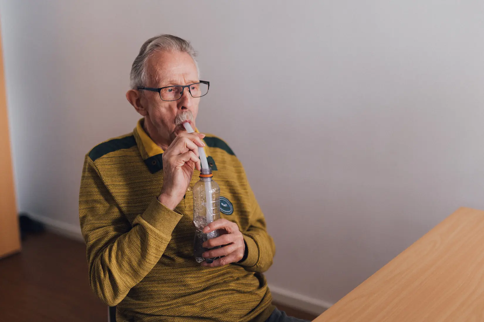 Mann bläst in Trinkhalm in der Praxis Custers