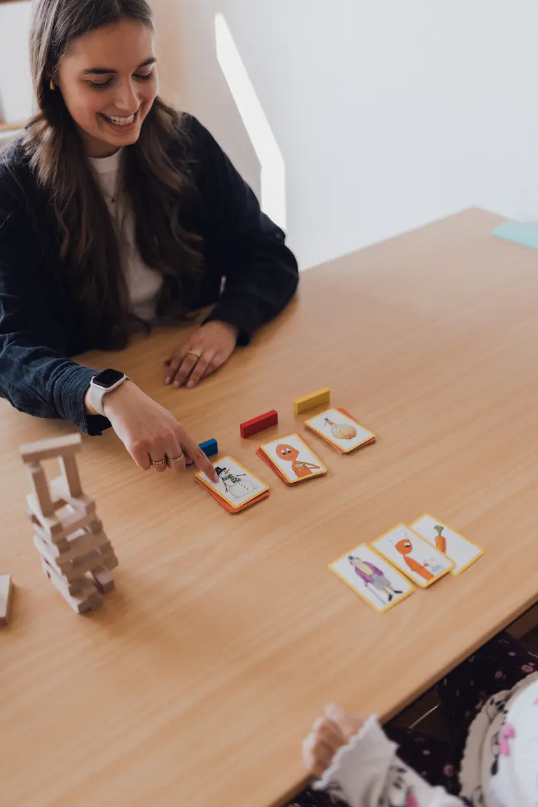 Bildkarten und Bausteine auf einem Tisch vor einer Logopädin