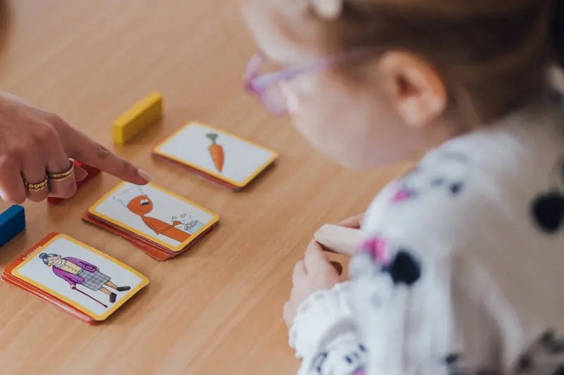 Bildkarten auf einem Tisch vor einem Kind