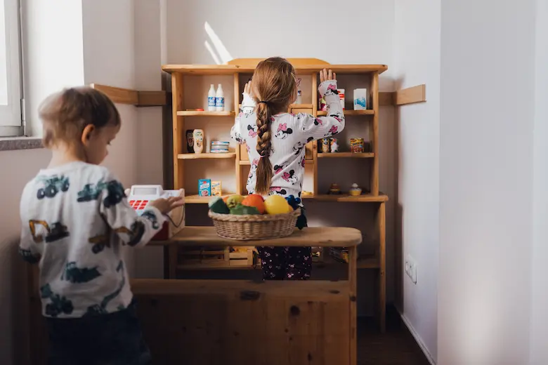 Zwei Kinder spielen in einem kleinen Einkaufsladen