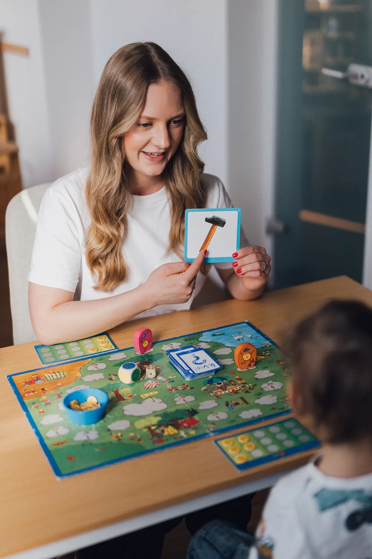 Kind spielt ein Brettspiel mit einer Logopädin