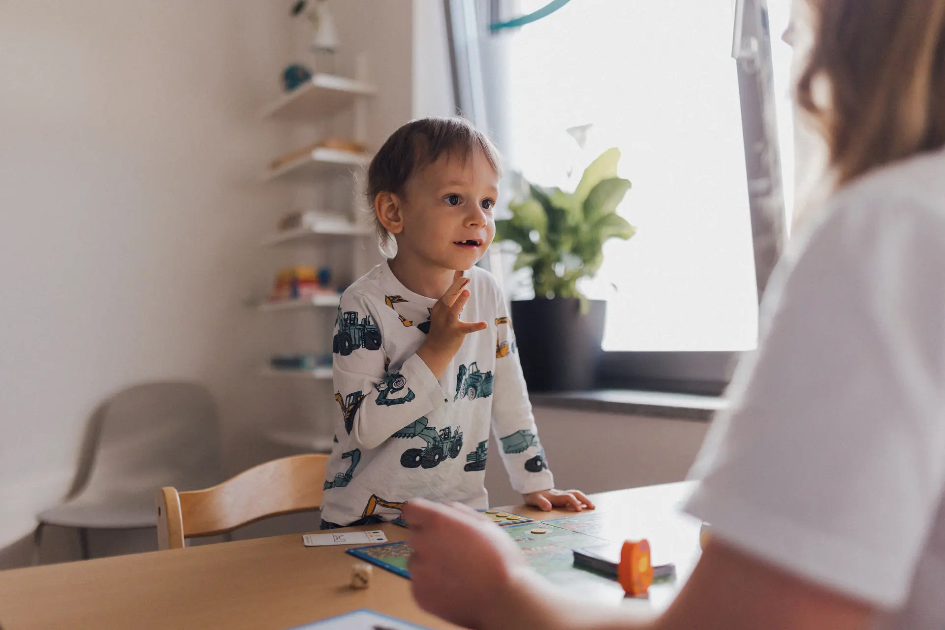 Kind spielt ein Brettspiel mit einer Logopädin