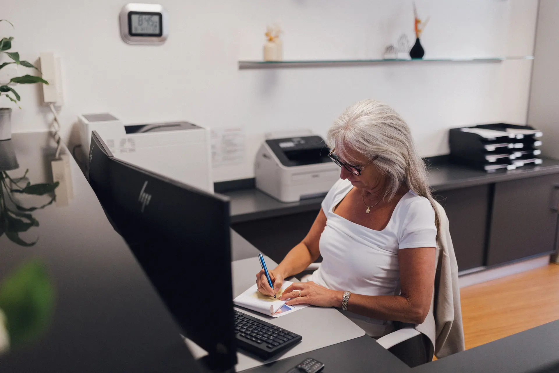 Sekretärin in der Praxis Custers schreibt auf einem Zettel